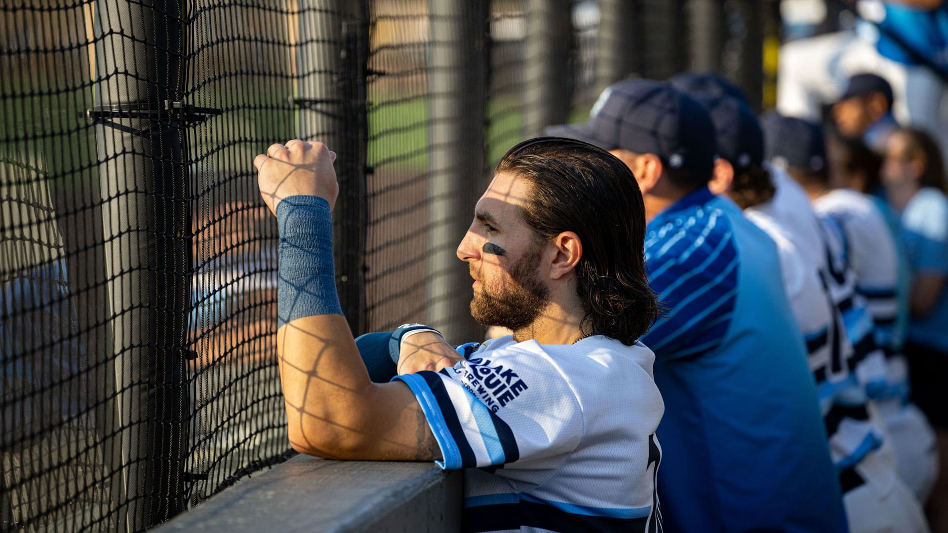 Blake Tiberi watches the on field action from the dugout as the sunsets